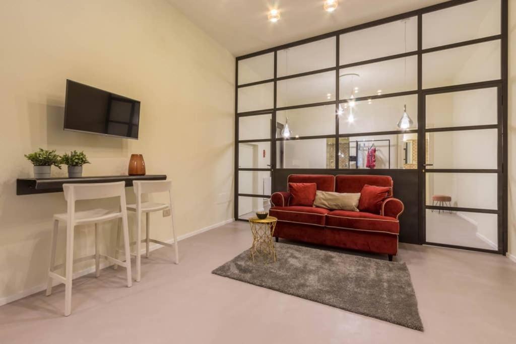 a living room with a red couch and a table at Suite Cagliari -99- in Cagliari