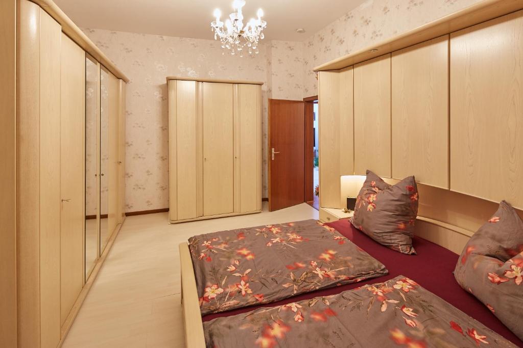 a bedroom with two beds and a chandelier at Mediterraneo-Rheinufer-Vallendar in Vallendar