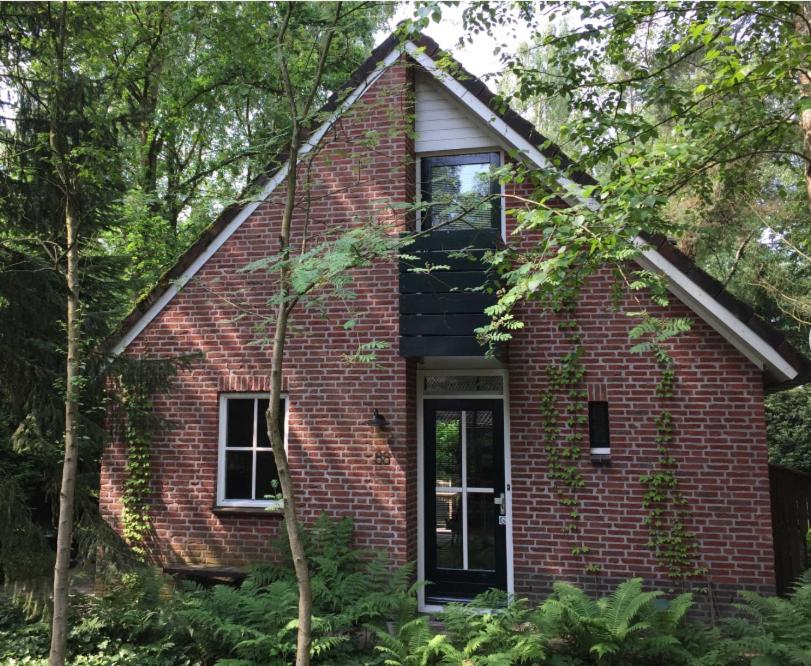 a red brick house with a window and a door at Natuurhuisje Even Niets in Zelhem