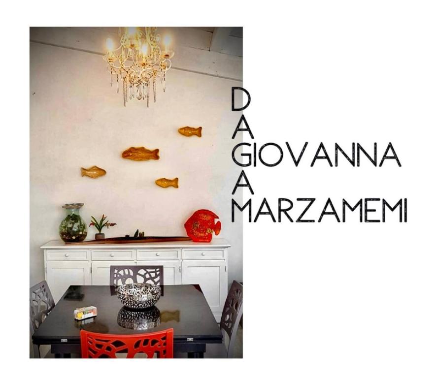 a dining room with a table and a chandelier at Da Giovanna a Marzamemi in Marzamemi