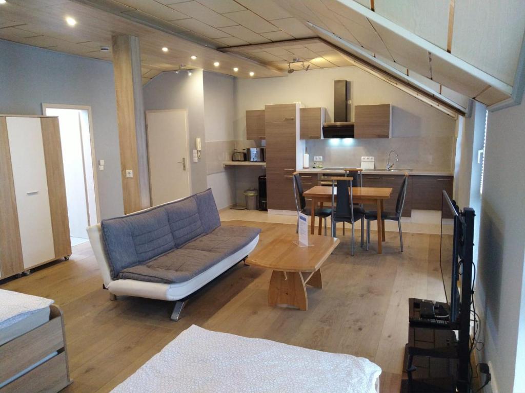 un soggiorno con divano e tavolo di Apartment-Design ad Altenstadt