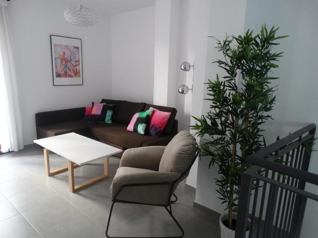 uma sala de estar com um sofá e uma mesa em Málaga Apartamentos - Jinetes, 23 em Málaga