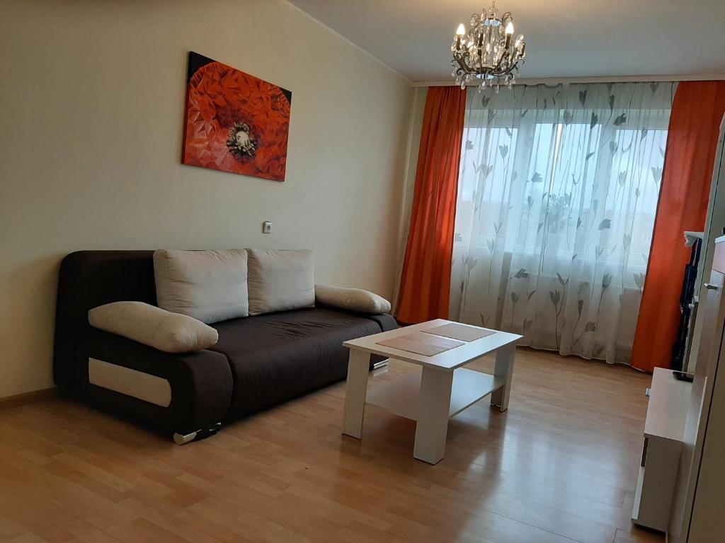 uma sala de estar com um sofá e uma mesa em Gražinos apartamentai em Panevėžys