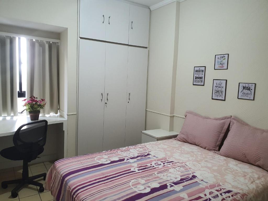 1 dormitorio con cama, escritorio y silla en Hospedagem Domiciliar - Ótima localização em Piedade en Recife
