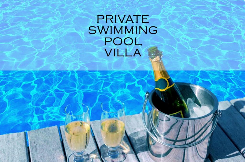 Belleview Villa في برشلونة: زجاجة من النبيذ في دلو بجوار حمام السباحة
