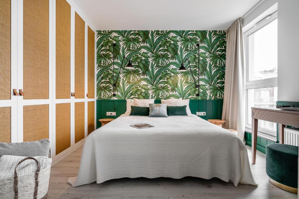 1 dormitorio con 1 cama grande y papel pintado con motivos florales en Apartament Ap175, en Gdansk