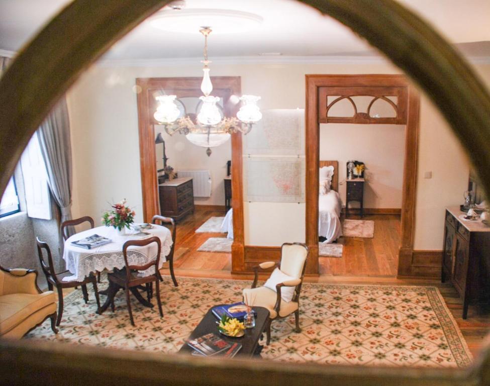 een woonkamer met een tafel en stoelen bij Casa Mindela Farmhouse in Vila do Conde