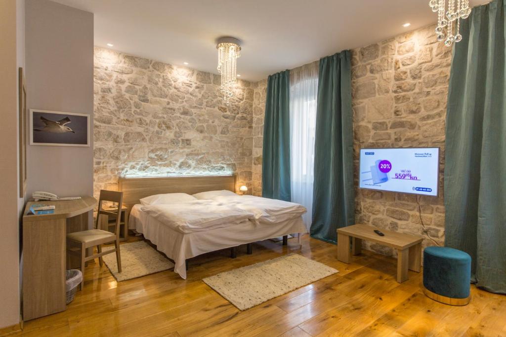 um quarto com uma cama e uma televisão de ecrã plano em Tifani Luxury Rooms em Split