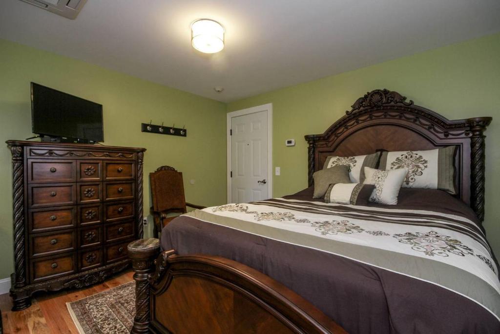 a bedroom with a bed and a dresser with a television at Cold Spring Hotel in Cold Spring