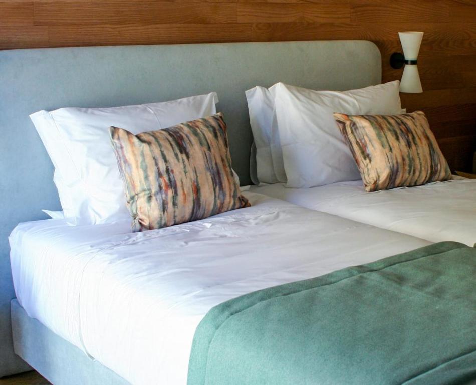 a bed with two pillows on top of it at Cascais City & Beach Hotel in Cascais