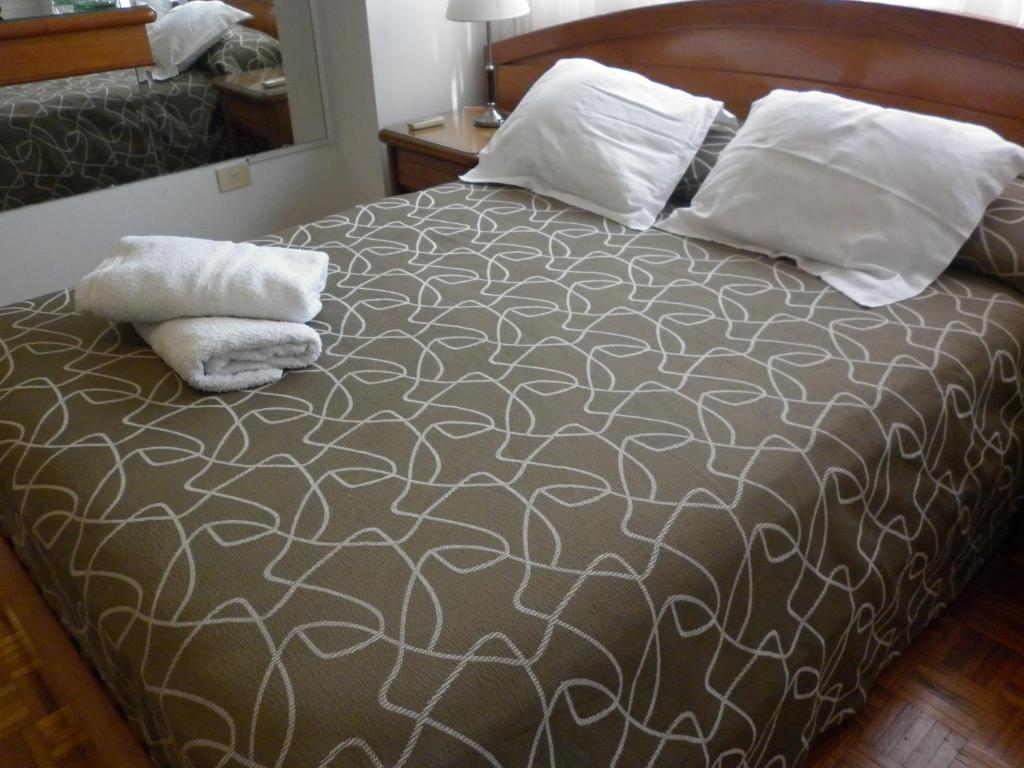 ein Schlafzimmer mit einem Bett mit zwei Kissen darauf in der Unterkunft Studio Suipacha in Buenos Aires