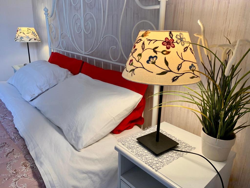 a bedroom with a bed with a lamp and a plant at Luna Piena B&B in Lecce