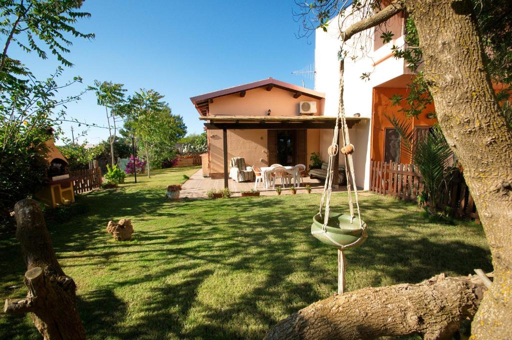 a yard with a swing in front of a house at Il Fenicottero in Masainas