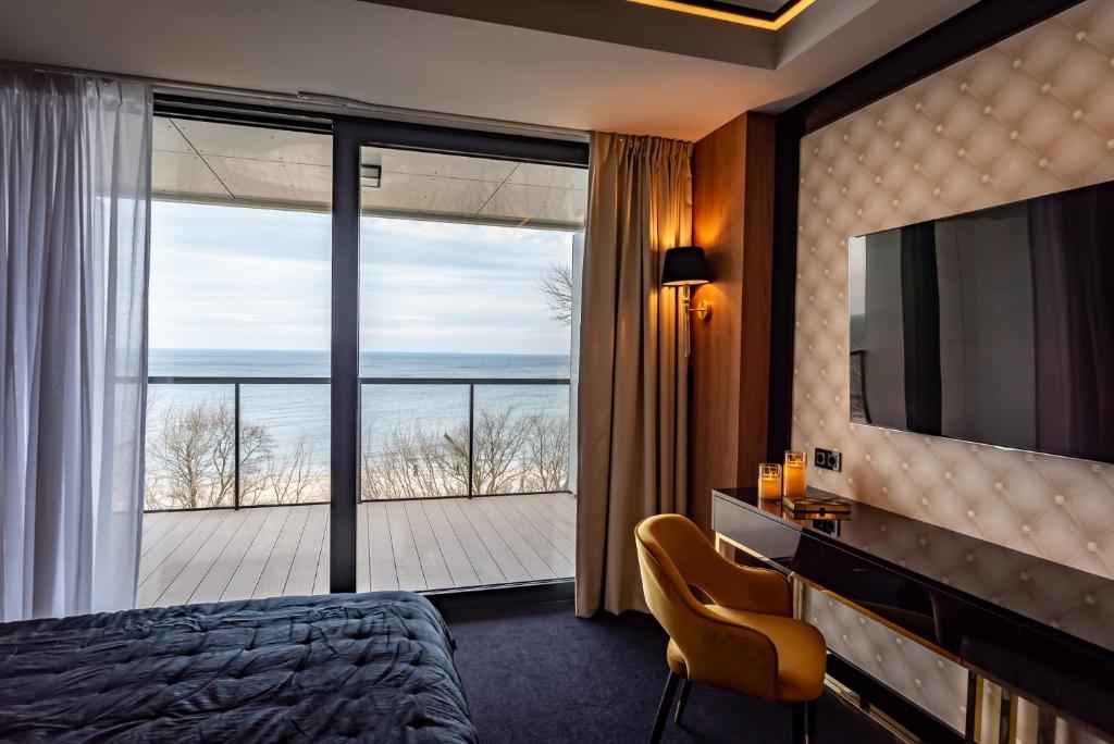 a hotel room with a bed and a large window at Golden Eye Apartament Seaside Park in Kołobrzeg