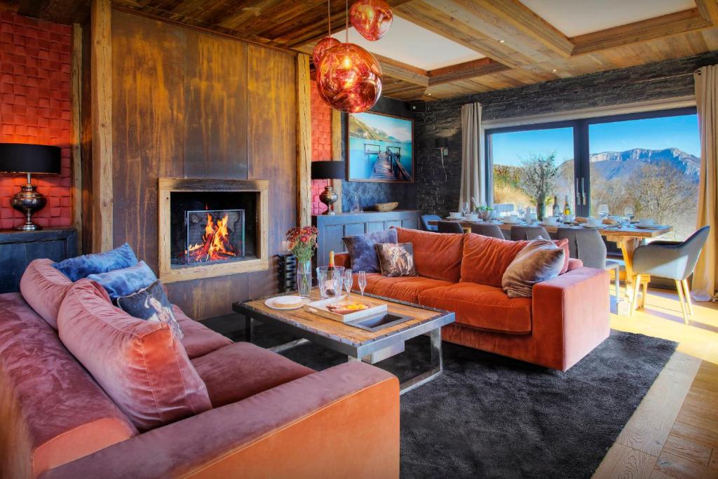 a living room with two couches and a fireplace at Chalet Kalyssia - OVO Network in Saint-Jorioz