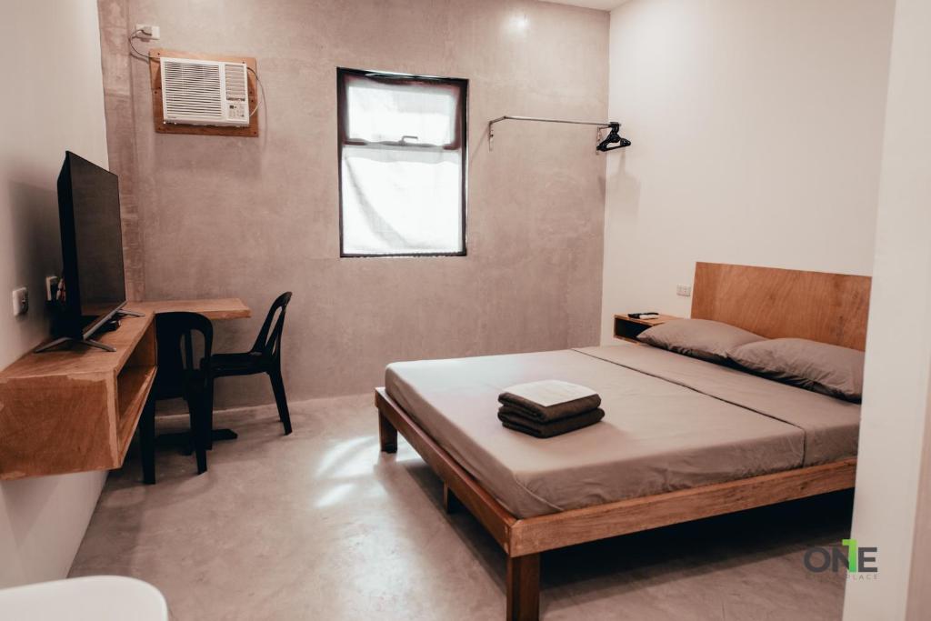 um pequeno quarto com uma cama e uma secretária em One Biñan Place em Biñan