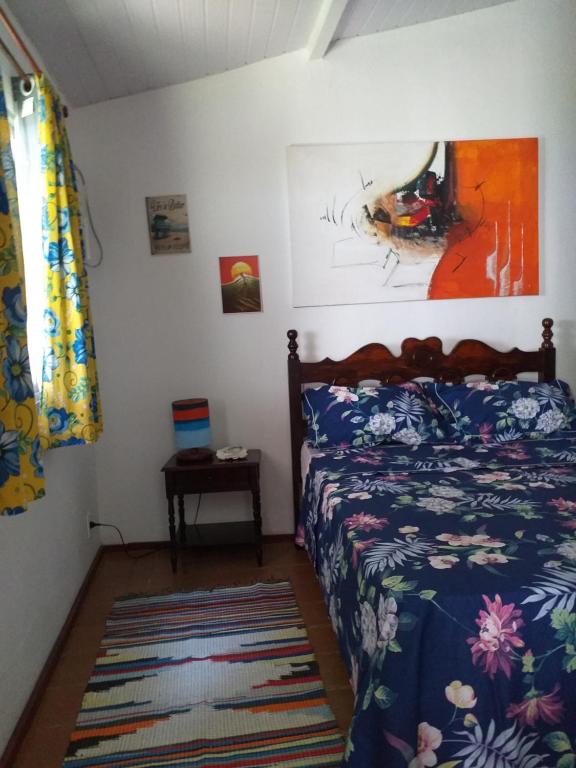 ein Schlafzimmer mit einem Bett und einem Wandgemälde in der Unterkunft Secret Recreio in Rio de Janeiro