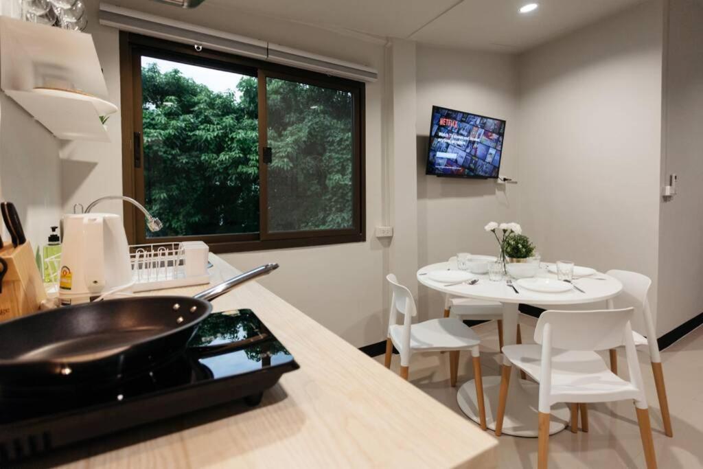 a kitchen with a sink and a table with chairs at S3 Silom26 · S3 Silom central, large room, full kitchen, WIFI, in Bangkok