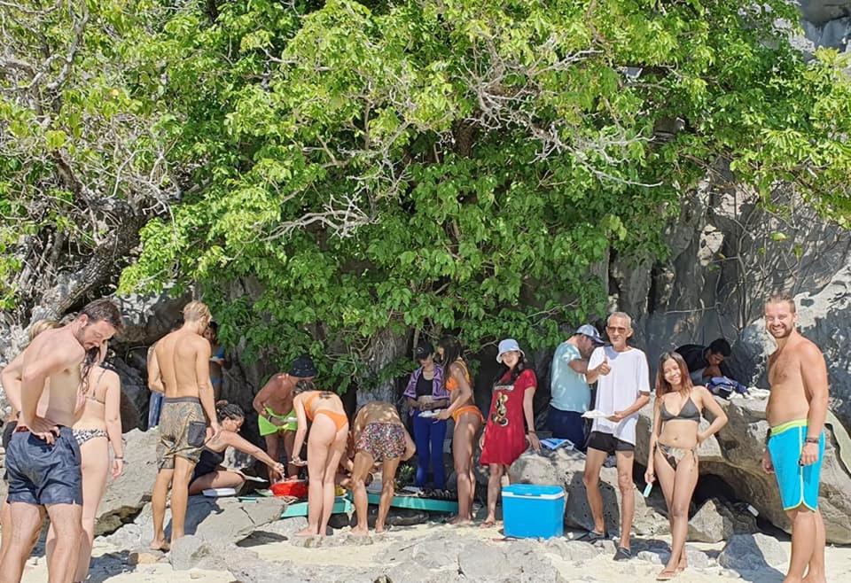 a group of people standing on a beach at Big Paul Hostel in El Nido