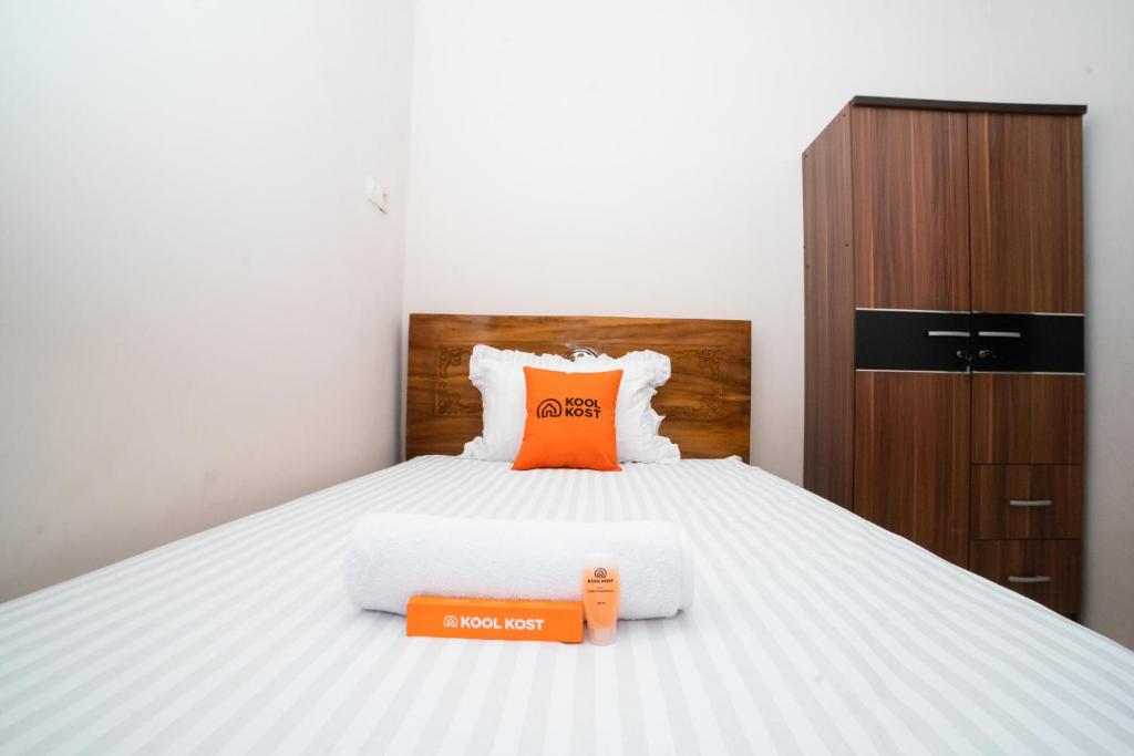 a bedroom with a bed with an orange box on it at KoolKost near RS Pelabuhan Jakarta - Minimum Stay 6 Nights in Jakarta