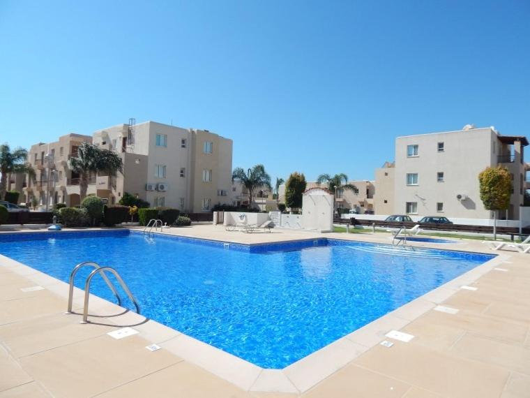 a large blue swimming pool with buildings in the background at Excellent 2 bed Apartment in Mandria