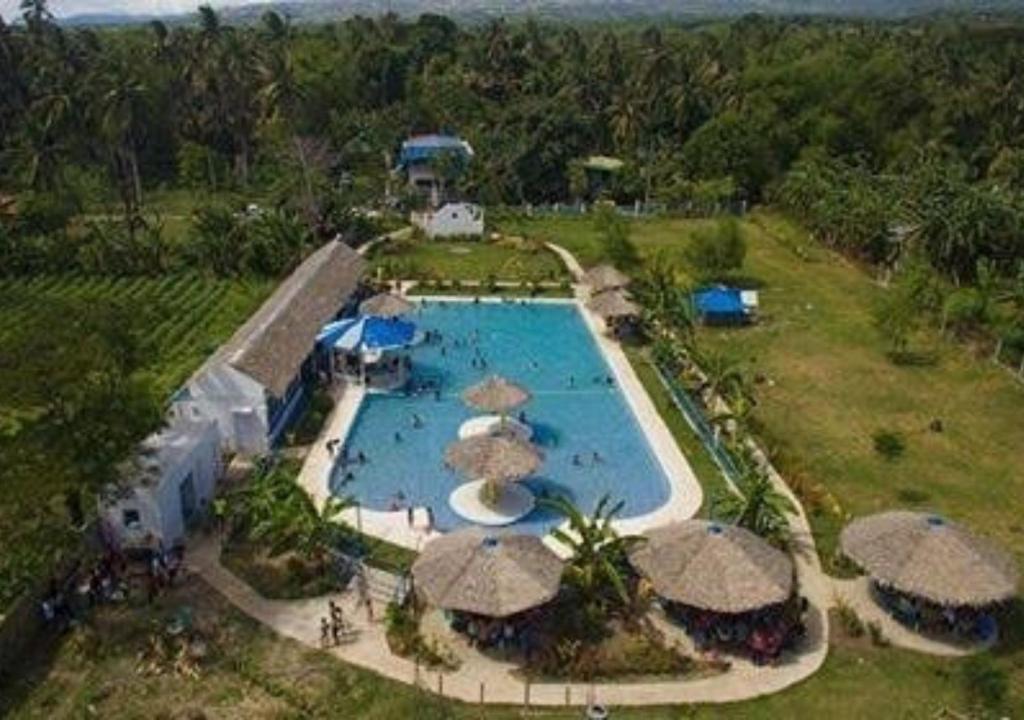 einen Luftblick auf einen Pool mit Sonnenschirmen in der Unterkunft SweetWater Resort in Zamboanguita