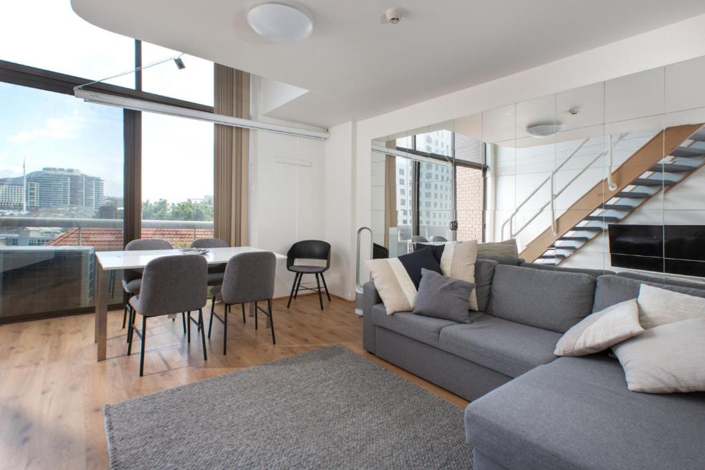 sala de estar con sofá y mesa en S203S - The Loft by Darling Harbour, en Sídney