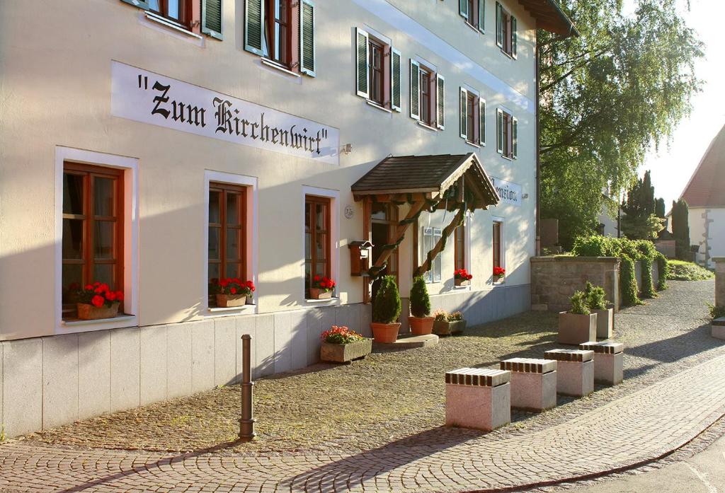 ein weißes Gebäude mit Pflanzen davor in der Unterkunft Landgasthof Zum Kirchenwirt in Kellberg