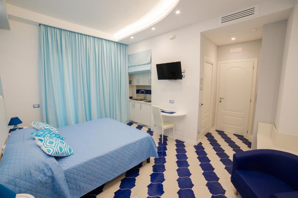 a bedroom with a blue bed and a desk at Marilisa Holidays in Maiori