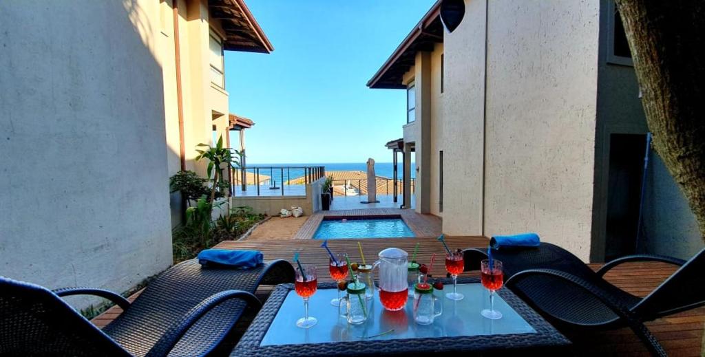 a table with wine glasses on it on a patio at Sovereign Paradise - Unit 22 in KwaDukuza