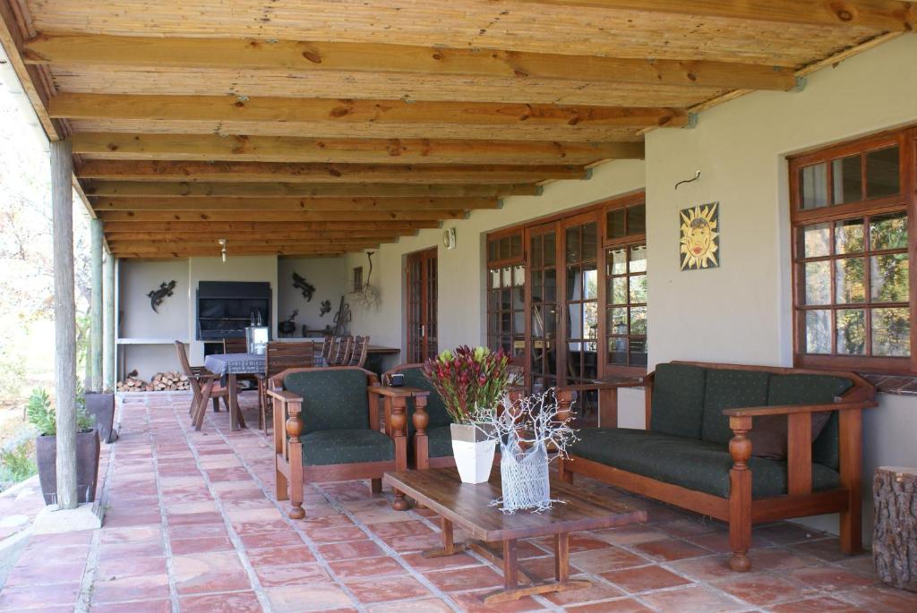 a patio with chairs and tables on a house at Heidedal Self-catering Guest House in Porterville