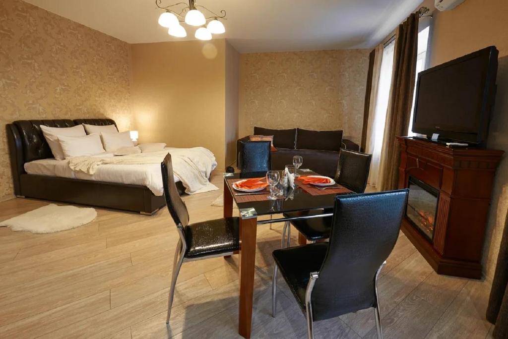 a bedroom with a bed and a table with chairs and a dining room at PaulMarie Apartments on Prs. Lenina, 51 in Gomel