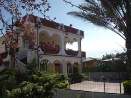 una casa grande con una palmera delante de ella en Villa Anna, en Agnone Bagni