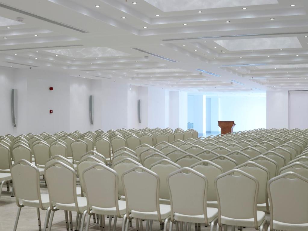 a large room with rows of chairs and a podium at Mitsis Selection Blue Domes in Kardamaina
