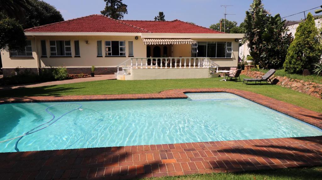 a swimming pool in front of a house at The Observatory, Luxury Suite in Observatory Home in Johannesburg