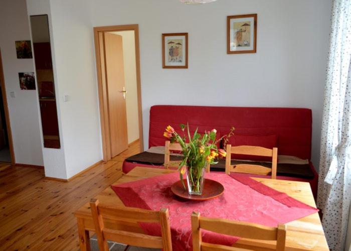 a dining room table with a vase of flowers on it at Unsere Ferienwohnung Stefan im Riesengebirge! in Dolní Lánov
