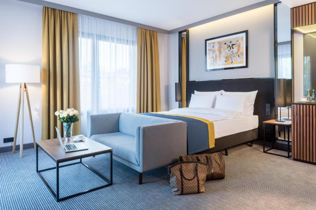 une chambre d'hôtel avec un lit et une chaise dans l'établissement Grand Ascot Hotel, à Cracovie