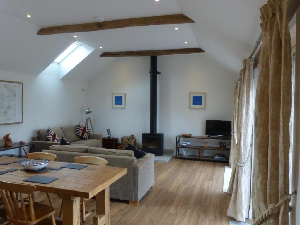 a living room with a table and a couch at The Woodshed - A newly built, 2 bedroom, cottage near Glastonbury in Glastonbury