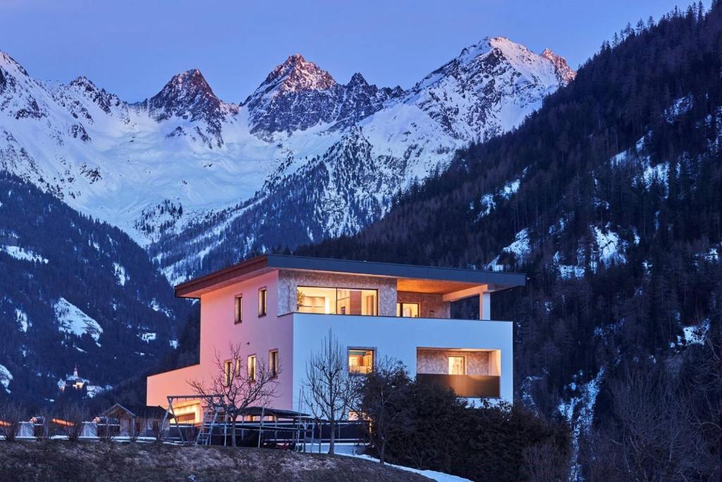 ein Haus auf einem Hügel mit Bergen im Hintergrund in der Unterkunft Apartment Naturnah in Kauns