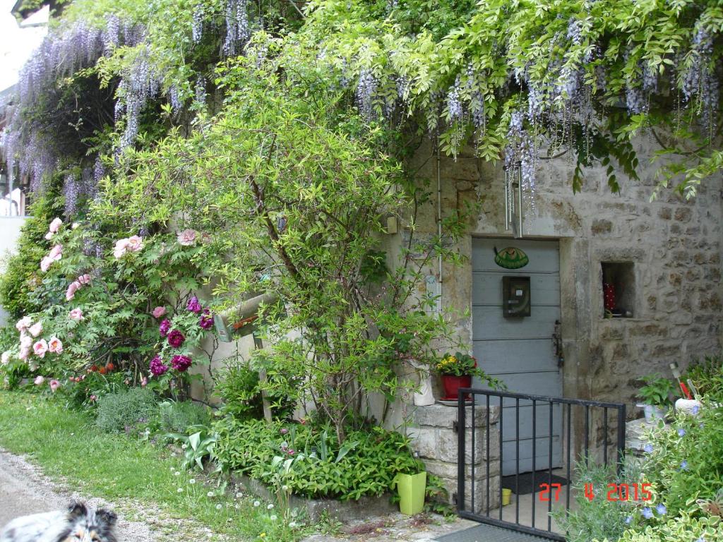 Ein Haus mit einem Haufen Blumen davor in der Unterkunft La Pie qui Chante in Saint-Lamain