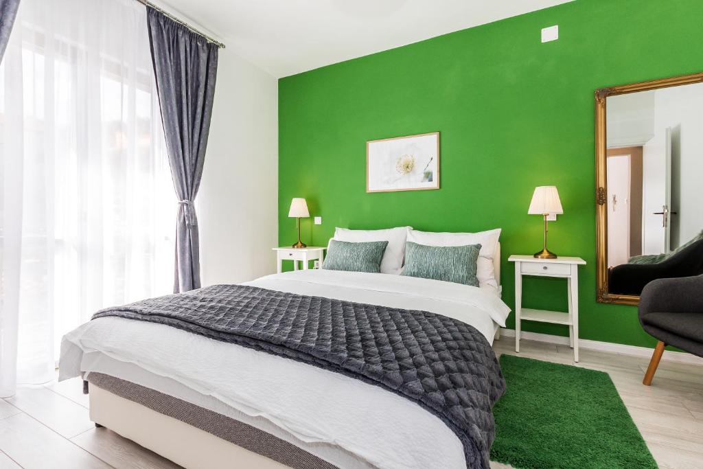Dormitorio verde con cama grande y espejo en Apartments Tanya en Šibenik