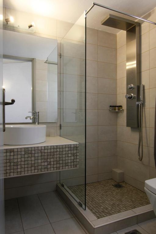 a bathroom with a shower and a sink and a tub at Mare Vista Hotel - Epaminondas in Batsi