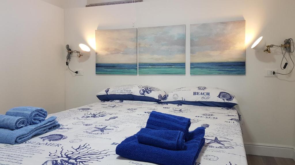 1 dormitorio con 1 cama y 2 sillas azules en Villa Santi, en Galtellì