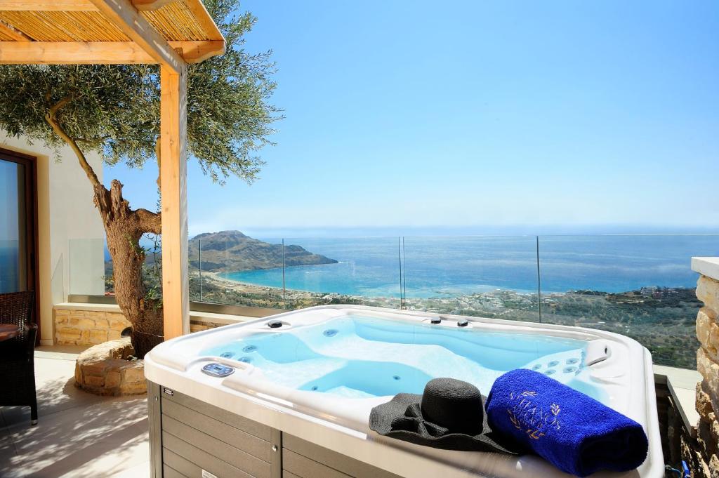 a jacuzzi tub with a view of the ocean at Stefanos Village in Myrthios