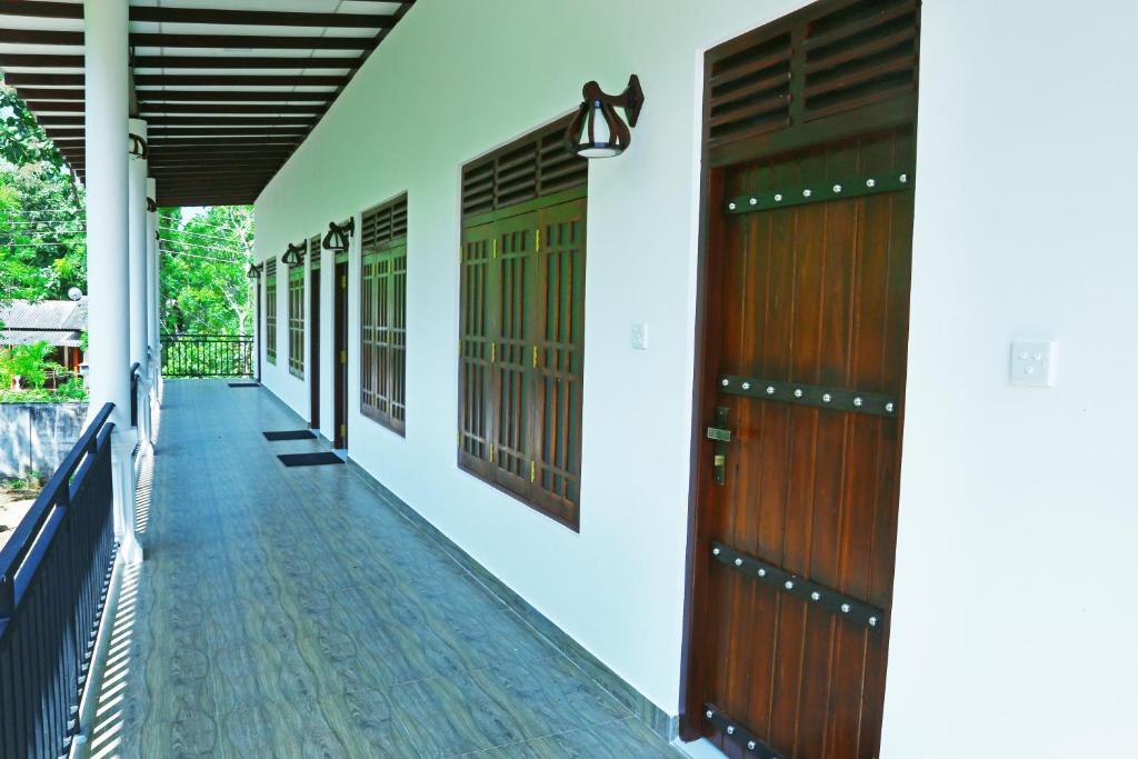 un corridoio di una casa con porte in legno di Emerald Guest House a Kataragama
