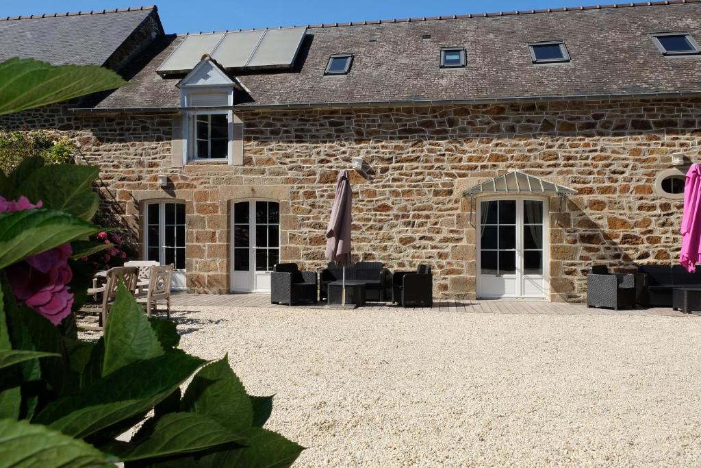 a brick building with a patio in front of it at Le Logis de Mordreuc in Pleudihen