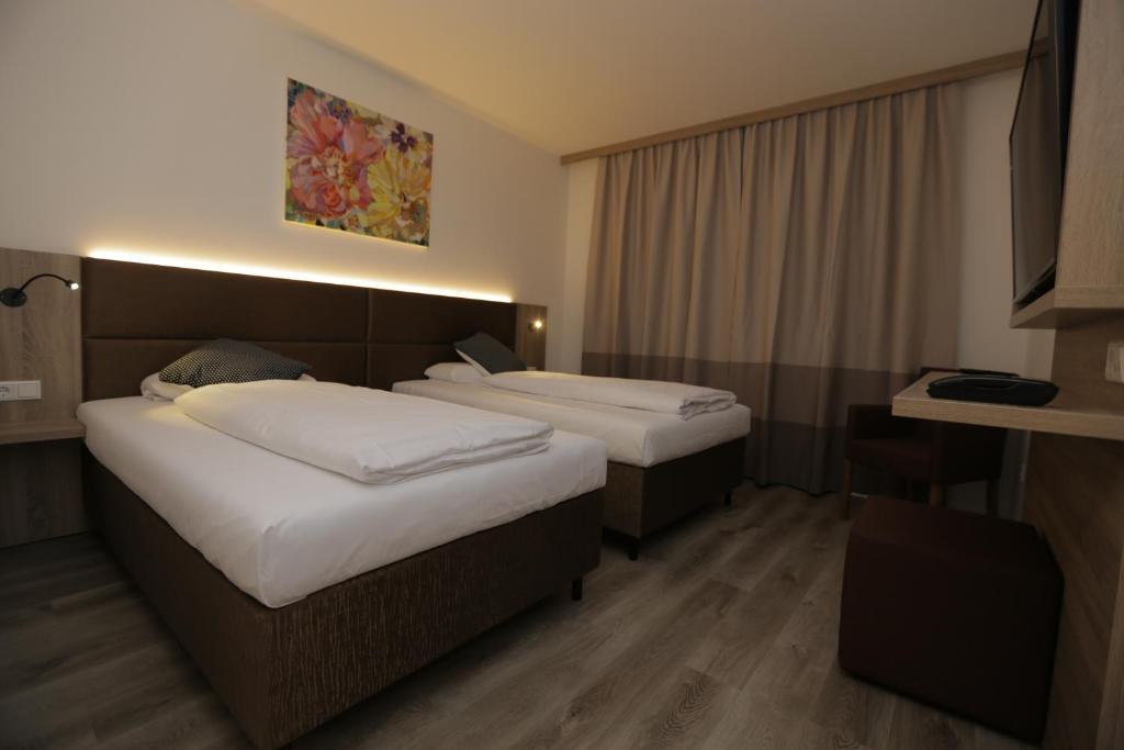 a hotel room with two beds and a window at Galeria Airport Hotel in Mörfelden-Walldorf