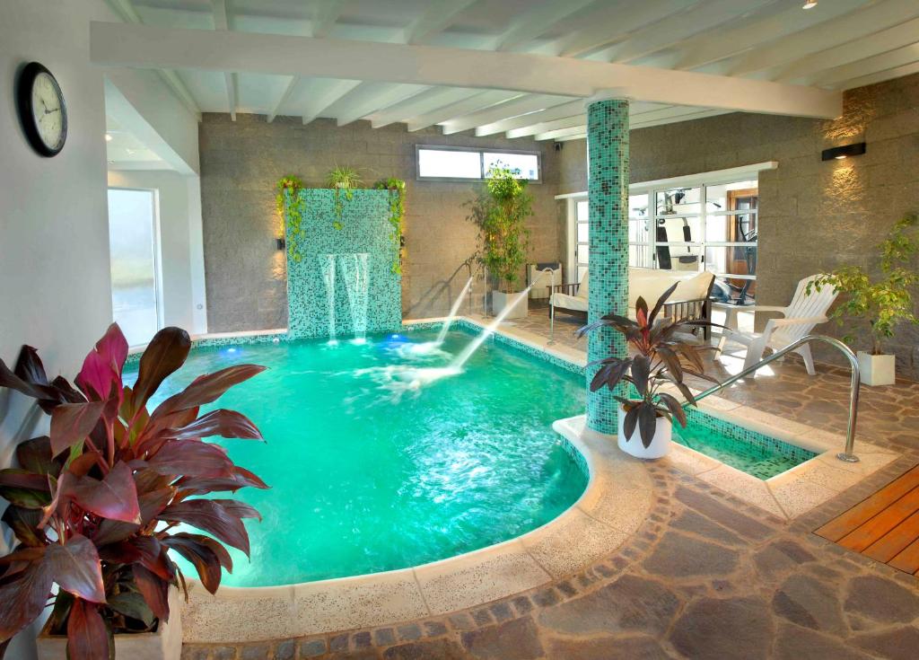 una gran piscina con una fuente en una casa en Bad-wiessee Apart Hotel & Spa en Villa General Belgrano