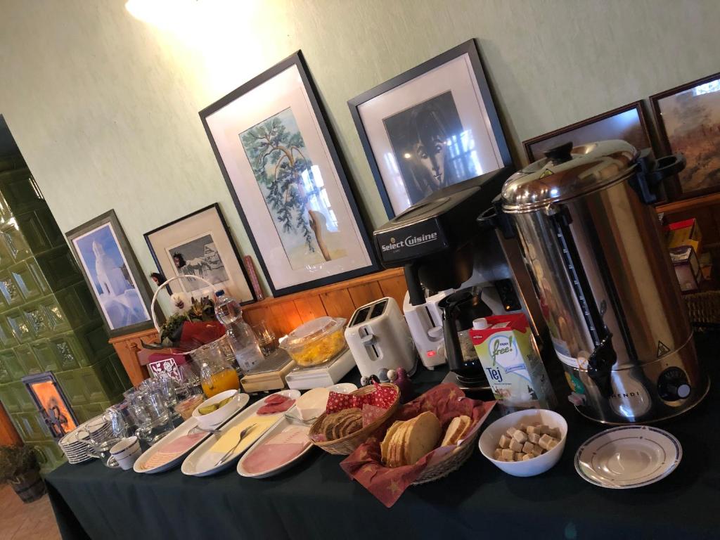 una mesa con platos de comida y una cafetera en Panzió Rust in Lànycsòk, en Lánycsók