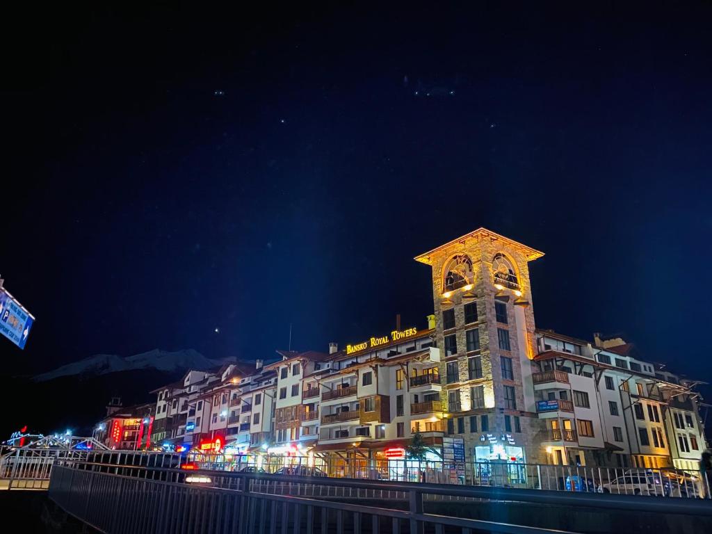 a large building with a clock tower at night at Bansko Royal Towers Hotel in Bansko